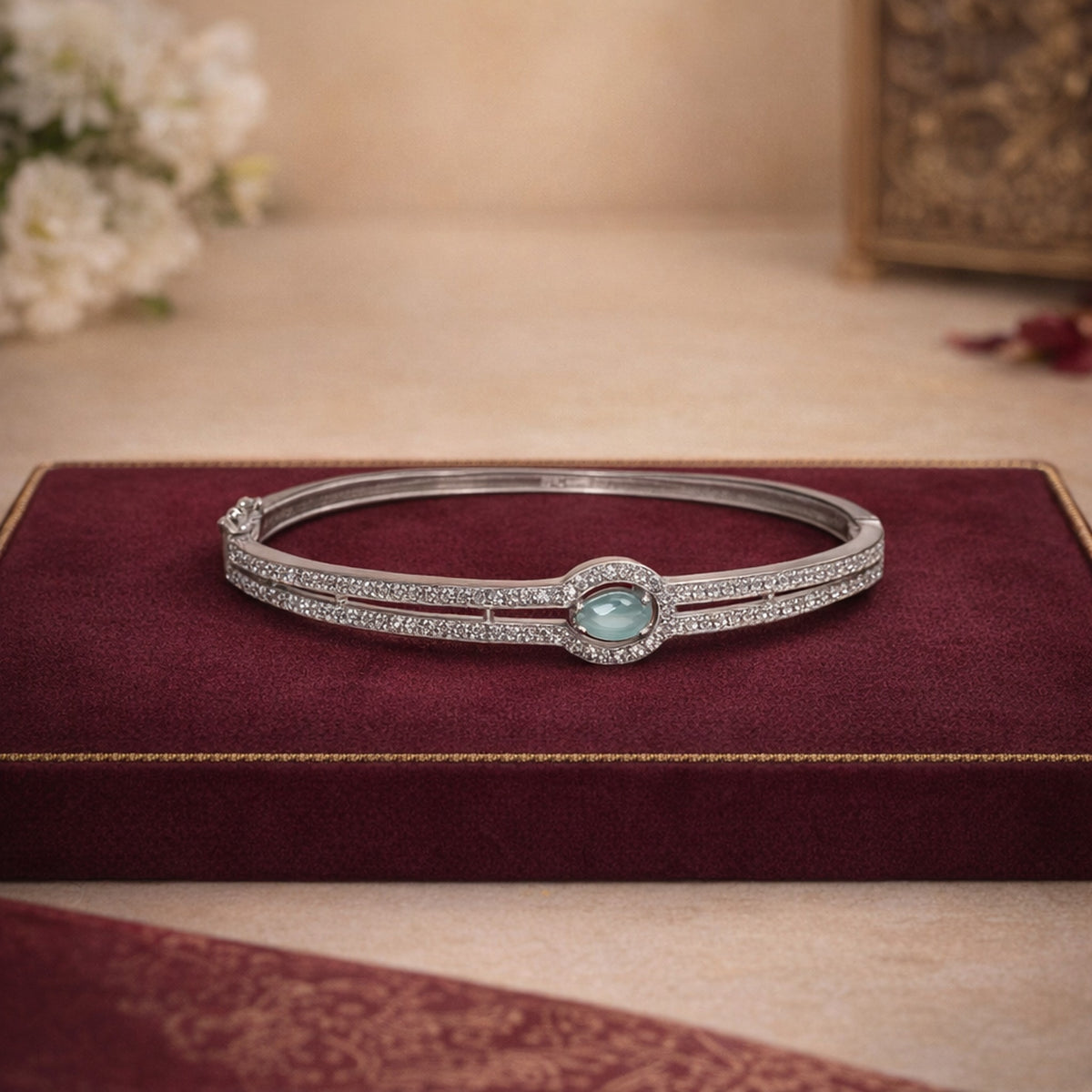 Silver-finish bracelet with aqua stone on burgundy velvet